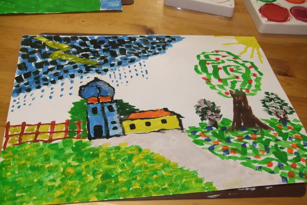 Gemeinsam gemaltes Bild mit Häusern, Baum und Regen