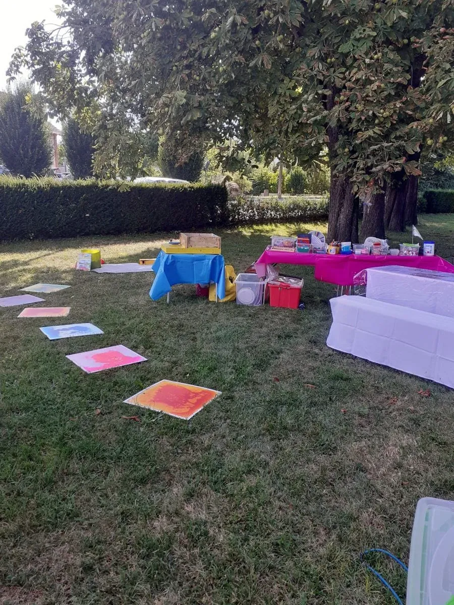 Bunte Bilder liegen zum Trocknen auf der Wiese