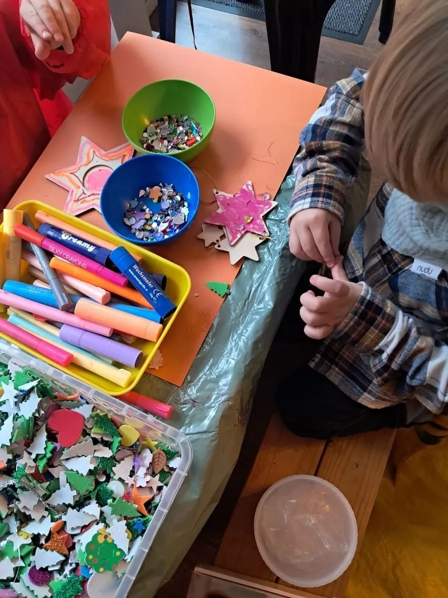Basteltisch mit Sternen, Perlen und Stiften