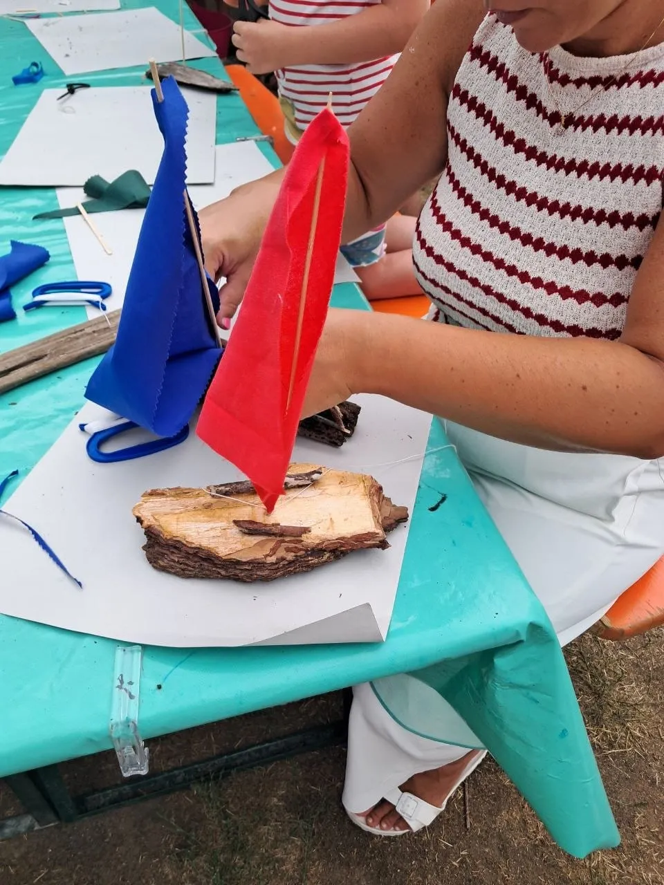 Segelboot aus Treibholz mit bunten Segeln