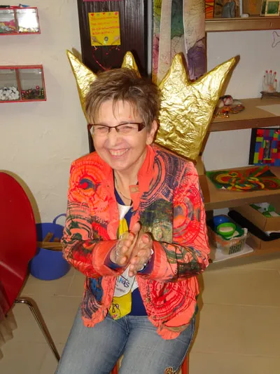 Christine von Dziembowski lacht, hinter ihr eine goldene Papierkrone