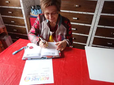 Christine von Dziembowski plant am Schreibtisch, vor ihr ein Kalender und ein APPLAUS-Blatt